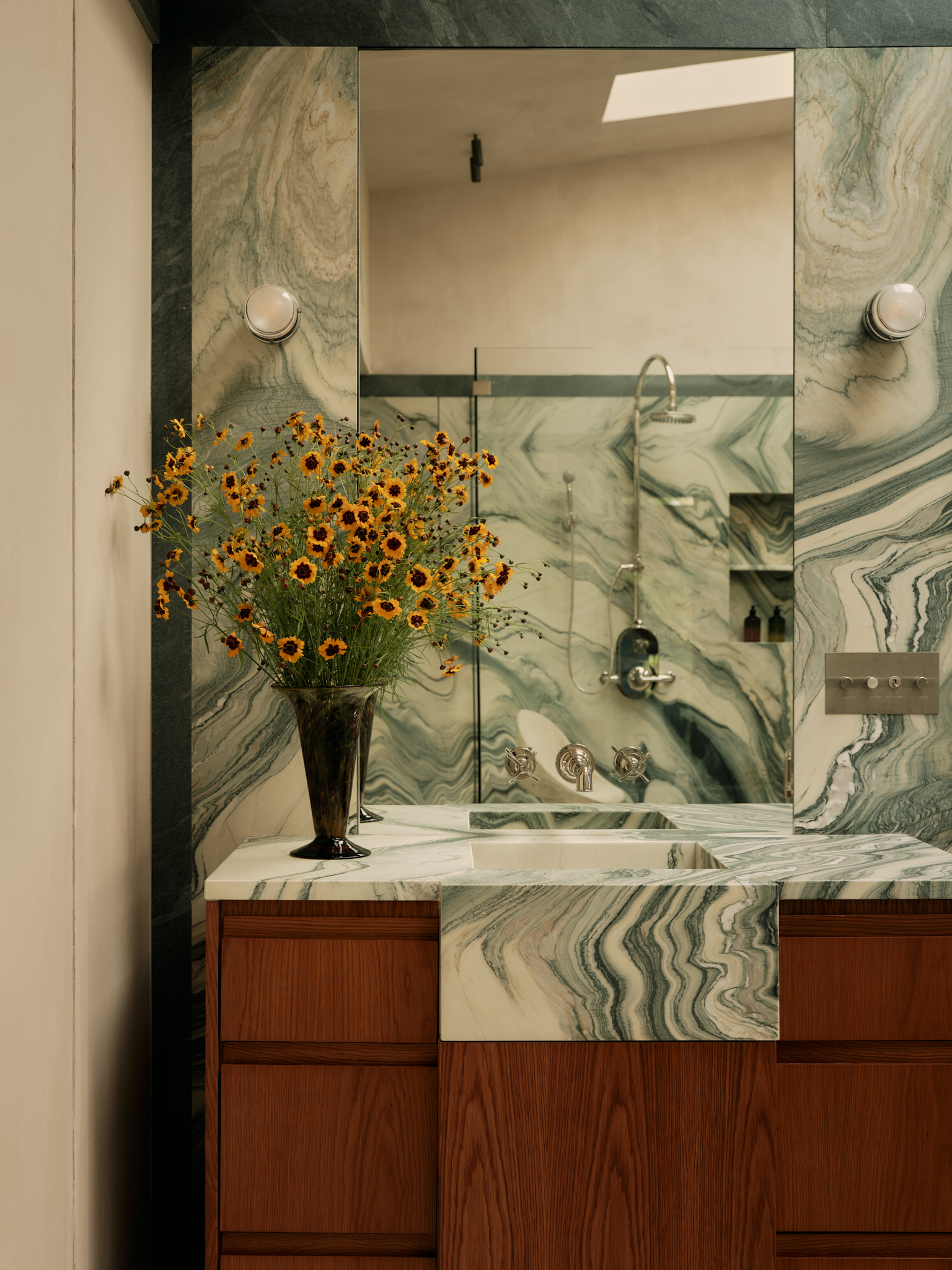 marble bathroom sink wiht a wooden vanity and flowers