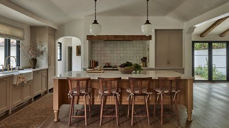 A neutral kitchen with a wooden island and a Delft tile backsplash
