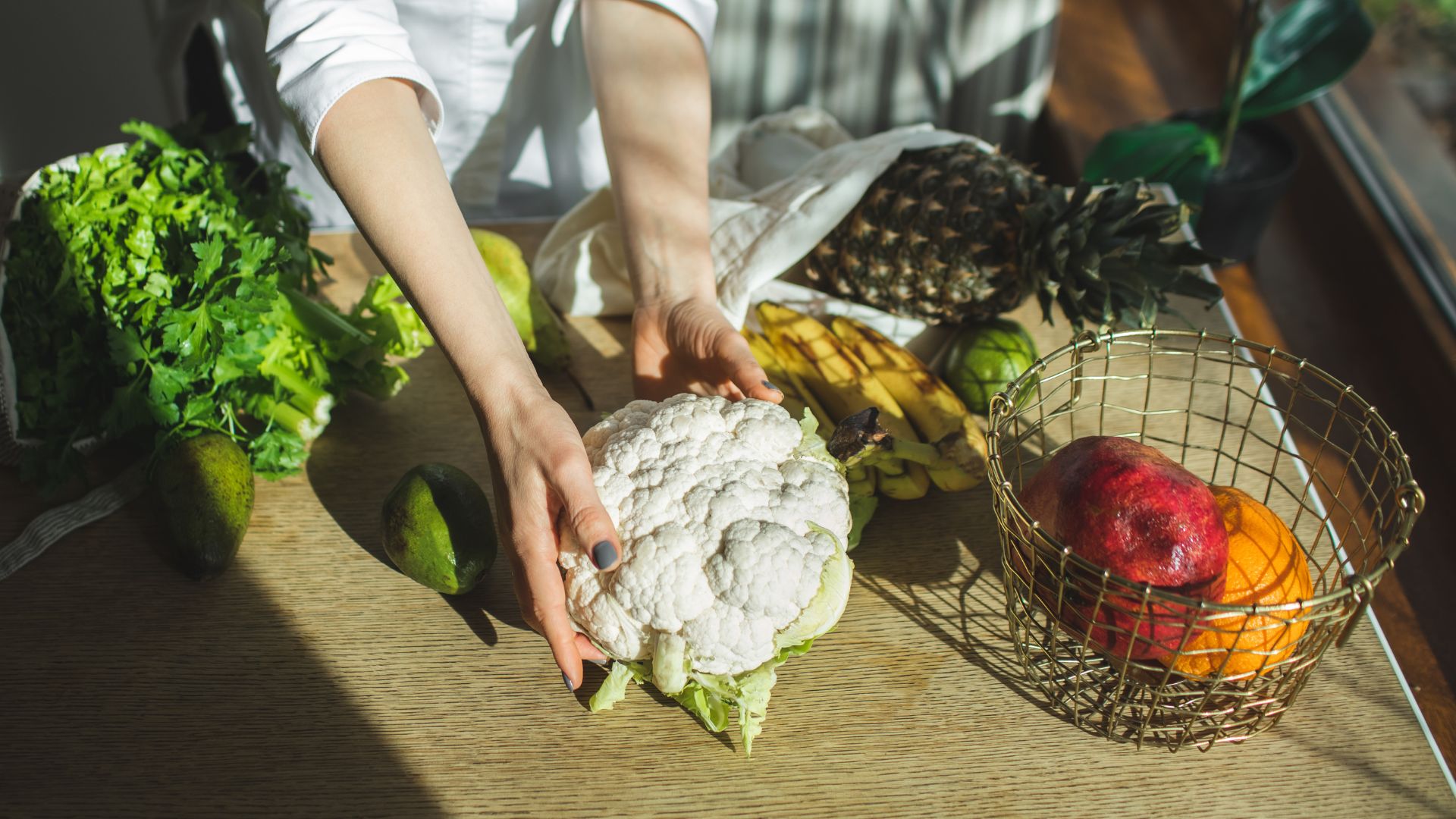 Woman setting out cauliflower on table