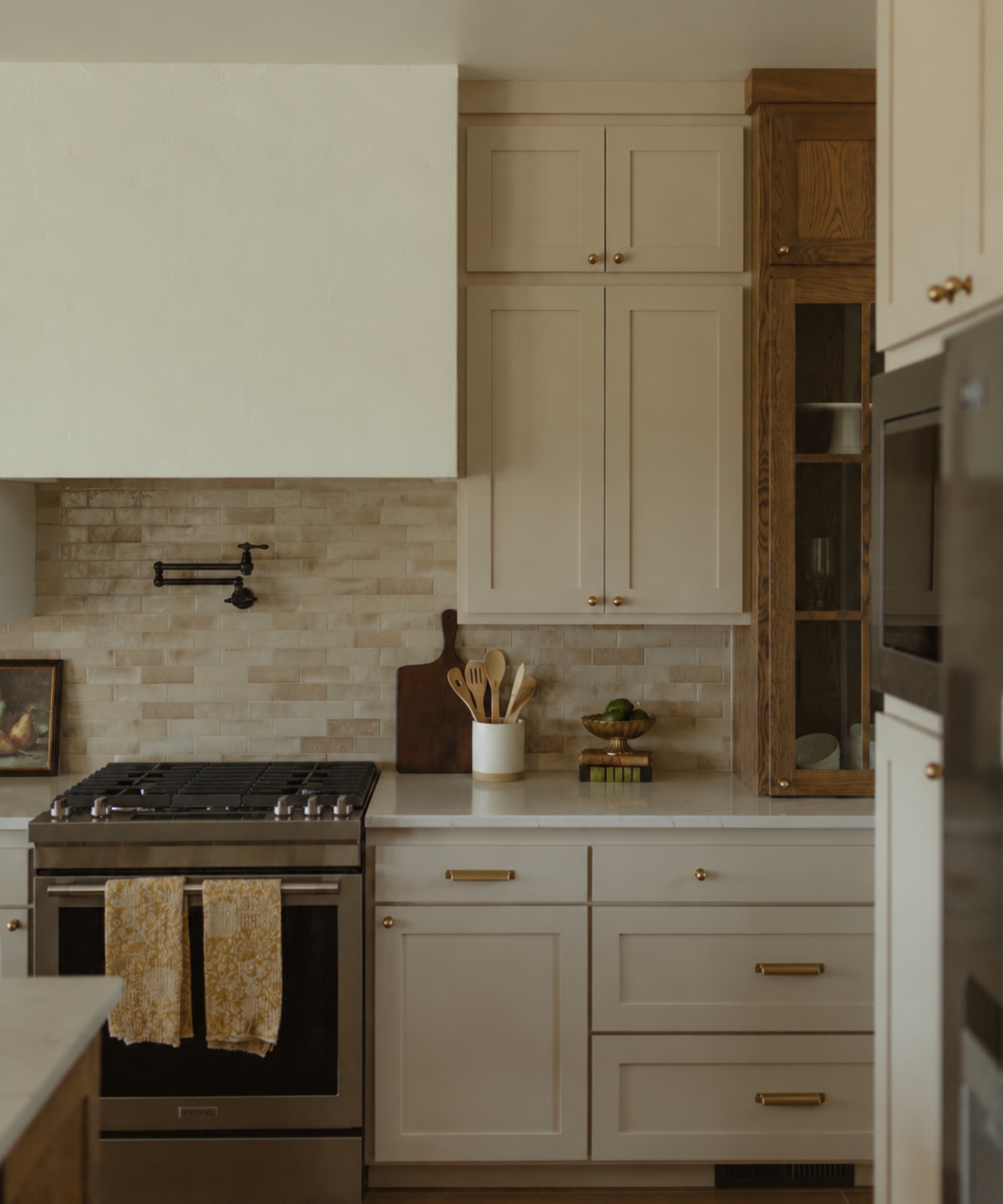 A neutral kitchen with mushroom color cabinets and beige tiles walls