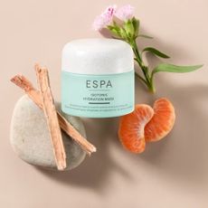 An ESPA isotonic hydration mask surrounded by orange pieces, vanilla sticks, and a flower