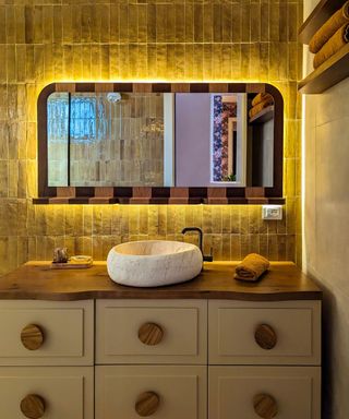 bathroom with textured brick tiled wall and rustic stone sink