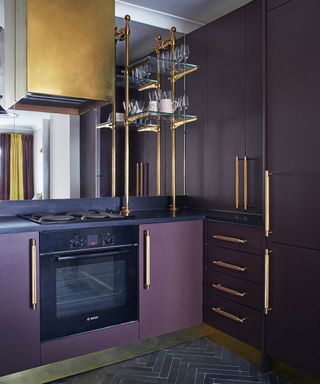 dark kitchen cabinetry with purple and gold accents
