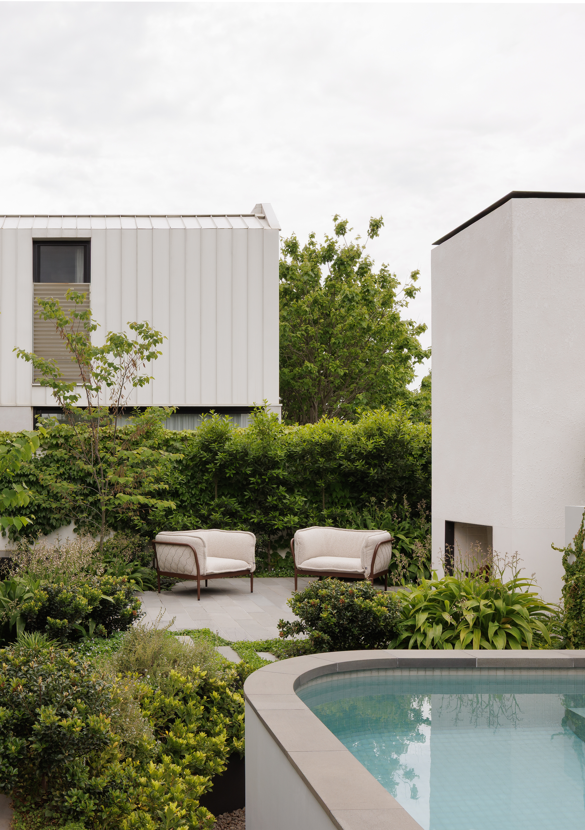 Outdoor seating are with open fire, plump armchairs and dense planting