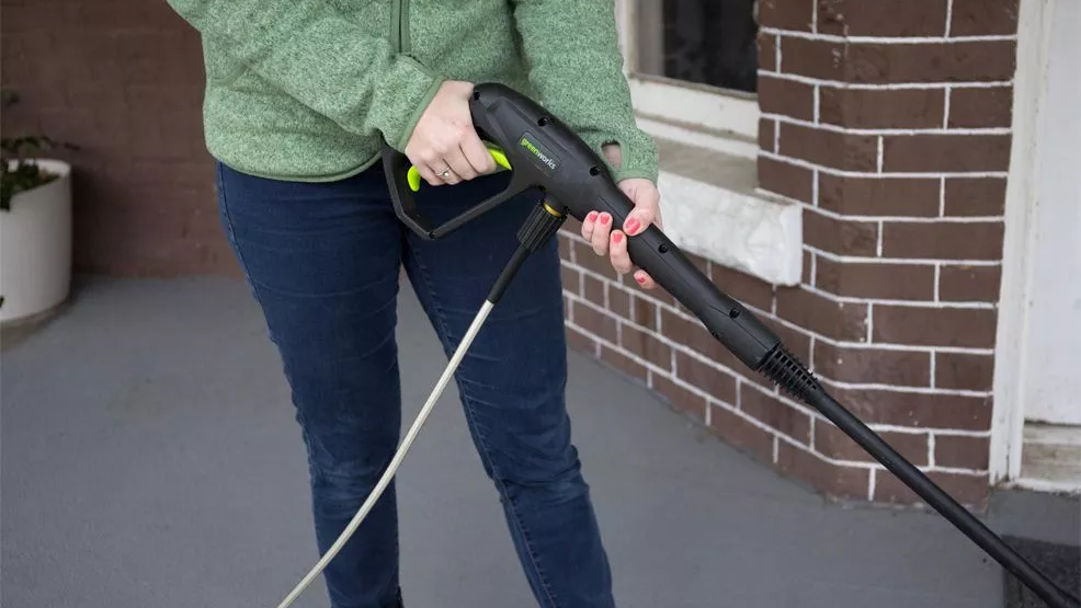 a woman holding the Greenworks GPW1501 spray gun