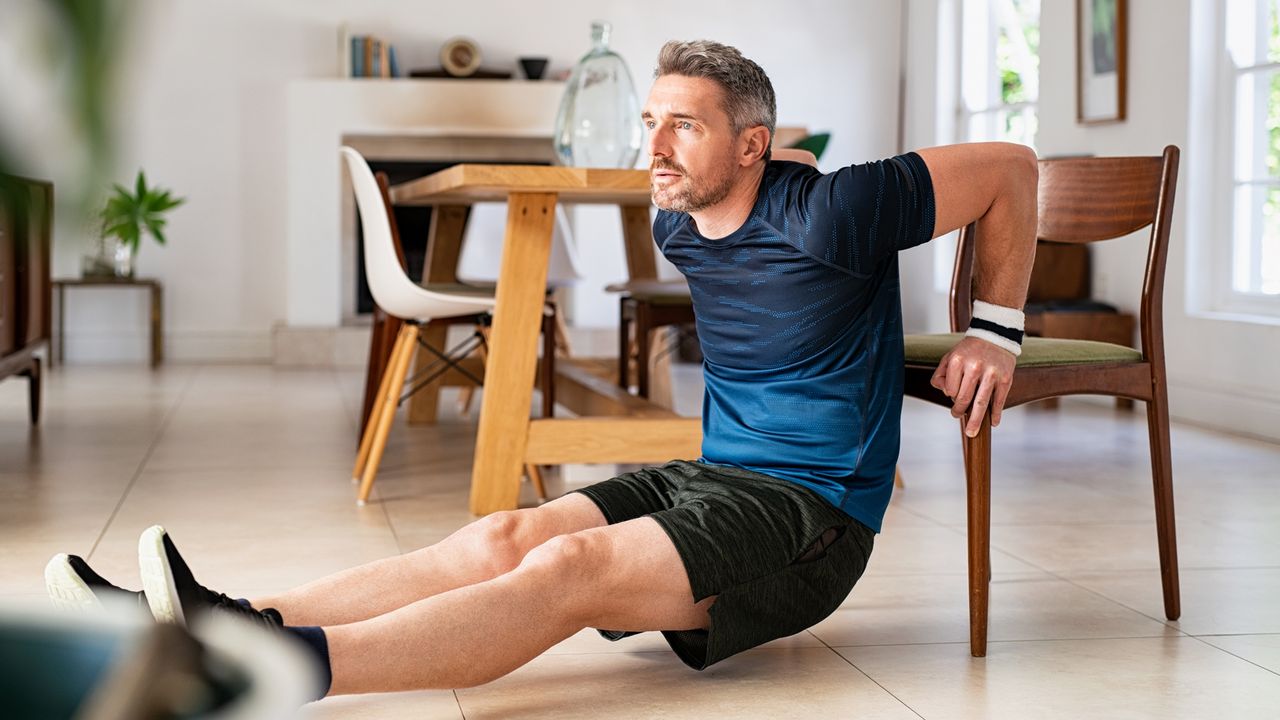 Man performs a tricep dip using a chair instead of a bench