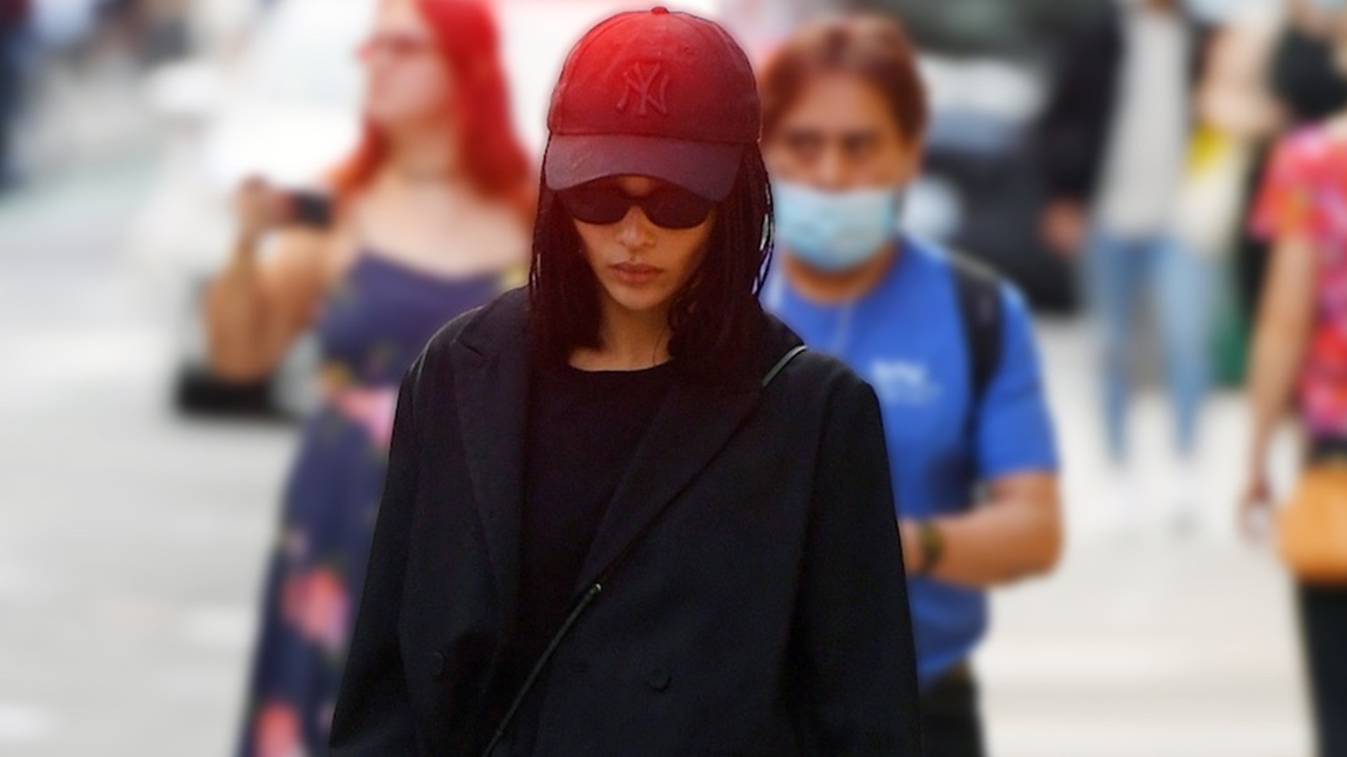 Zoe Kravitz walking in NYC wearing a black New York Yankees baseball cap and all-black outfit