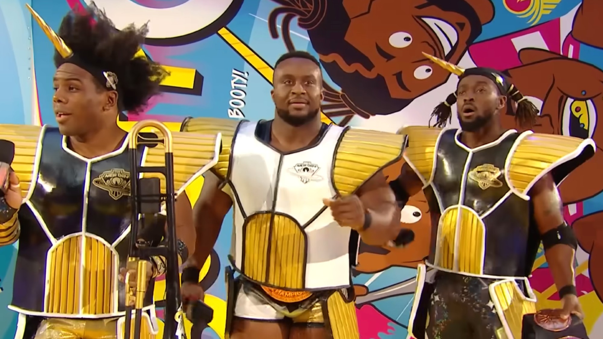 Xavier Woods, Big E, and Kofi Kingston at WrestleMania in Dragon Ball inspired Saiyan armor. Kofi and Xavier are wearing black suits, and Big E is wearing white in the center. 