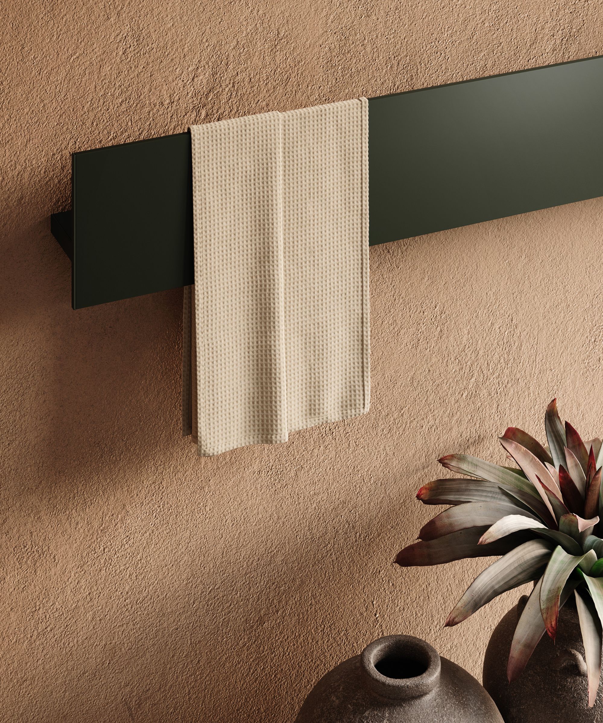 A contemporary flat-panel radiator in matte black, styled with a neutral towel and rustic terracotta backdrop for a modern Mediterranean feel.
