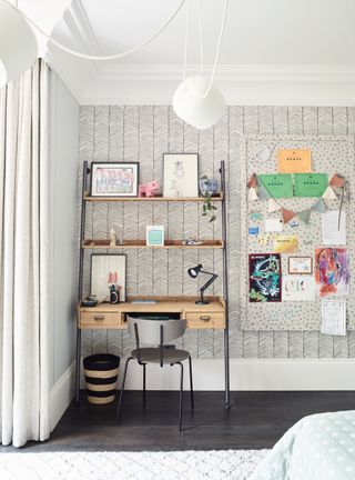 a kids room with a desk and wallpaper