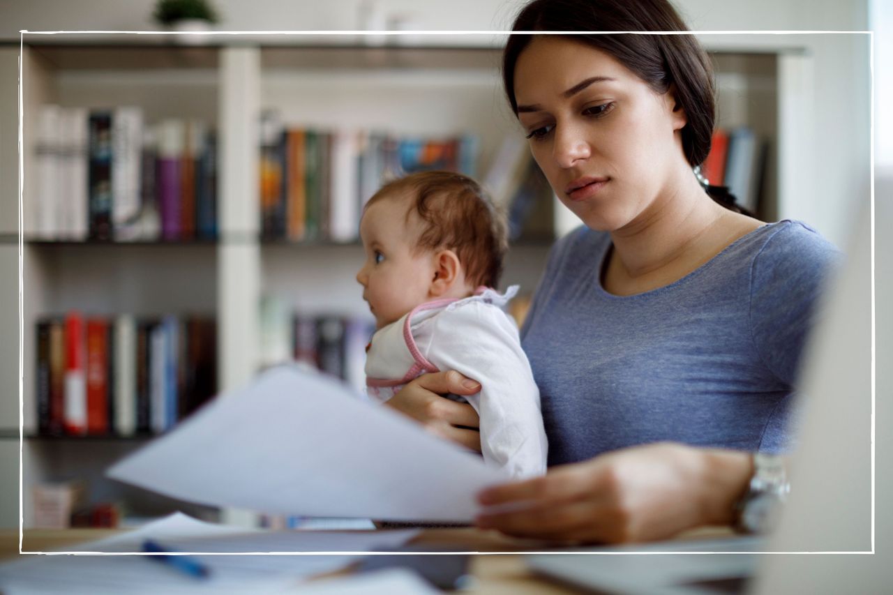 mother sitting at a table looking at bills while holding her baby