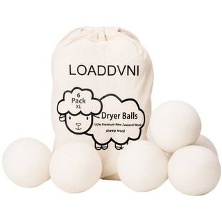 Cream Wool Dryer Balls piled on each other and with a cotton bag featuring a black outlined sheep graphic