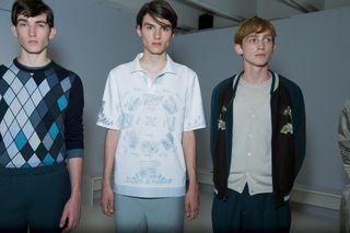 Three male models wearing clothing by Pringle of Scotland in light shades.