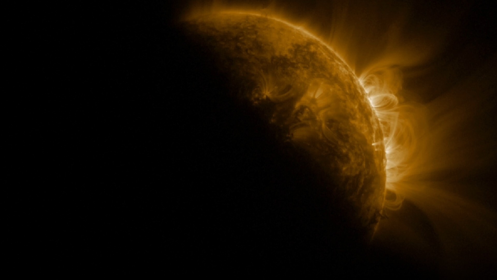 An image of the sun in space, with a dark shadow partially covering it where the moon crosses in front of it
