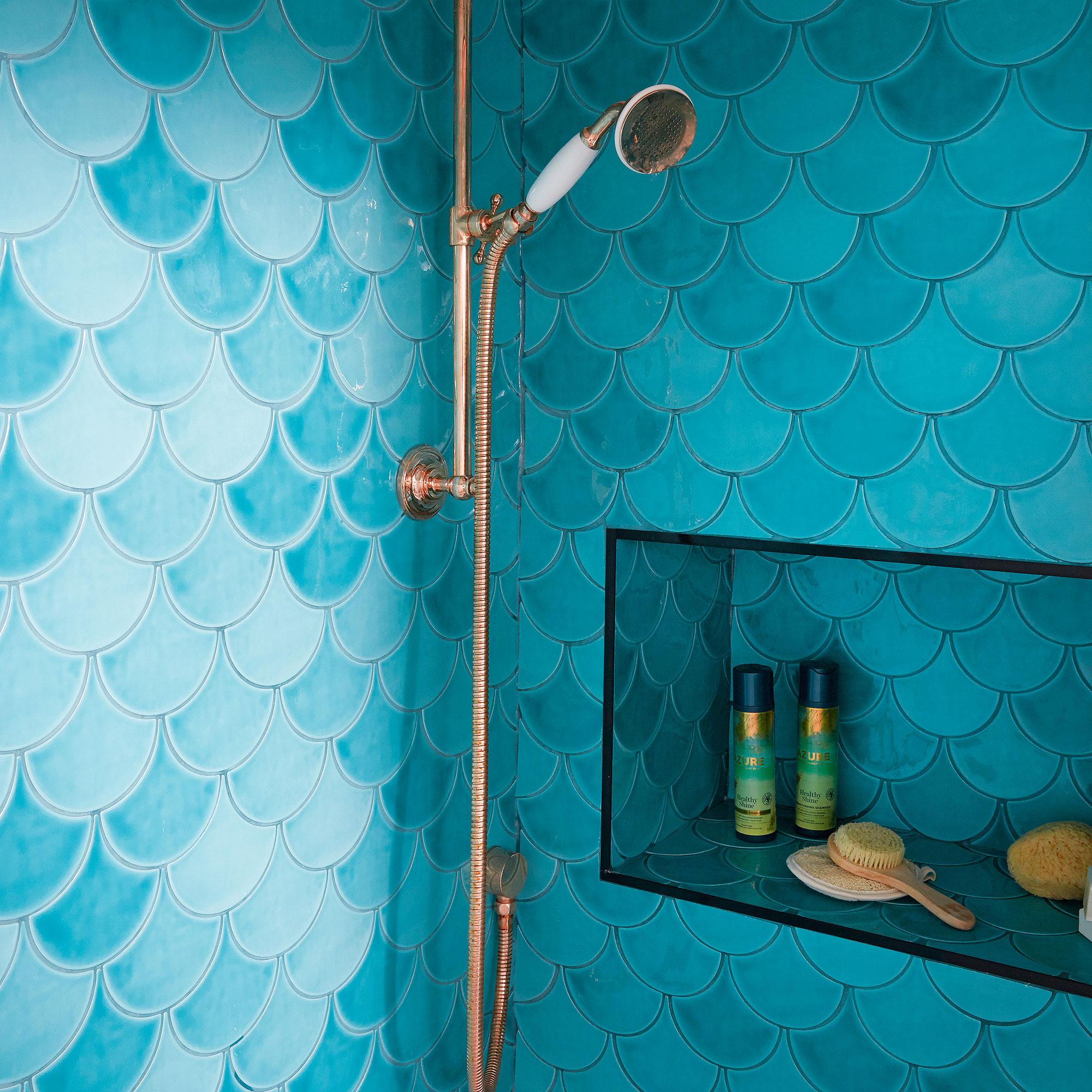 Shower covered in turquoise blue scalloped tiles