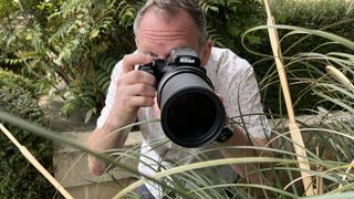 Nikon Coolpix P1100 lifestyle image of Adam Waring shooting through grasses