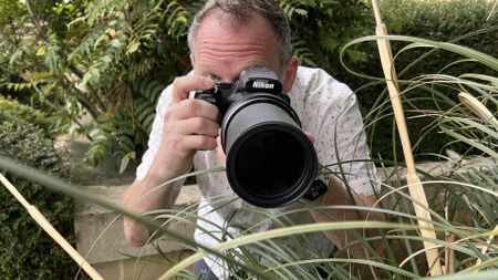 Nikon Coolpix P1100 lifestyle image of Adam Waring shooting through grasses 