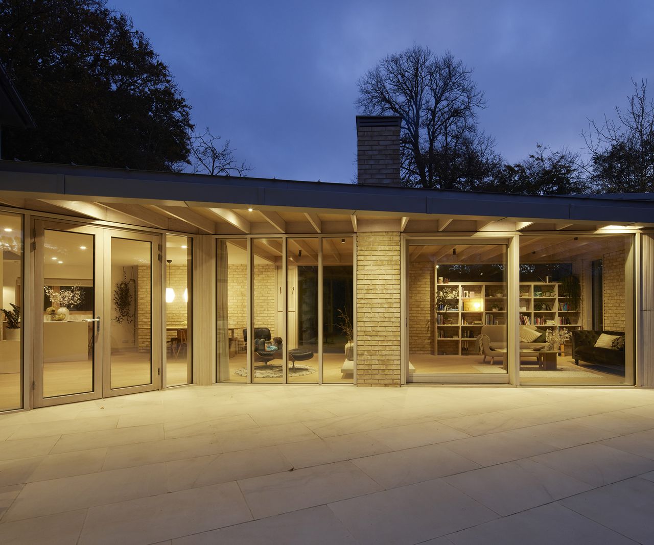A contemporary glazed extension with an extended roof creating a covered terrace