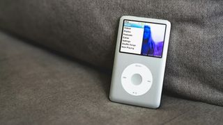 A silver iPod on a sofa