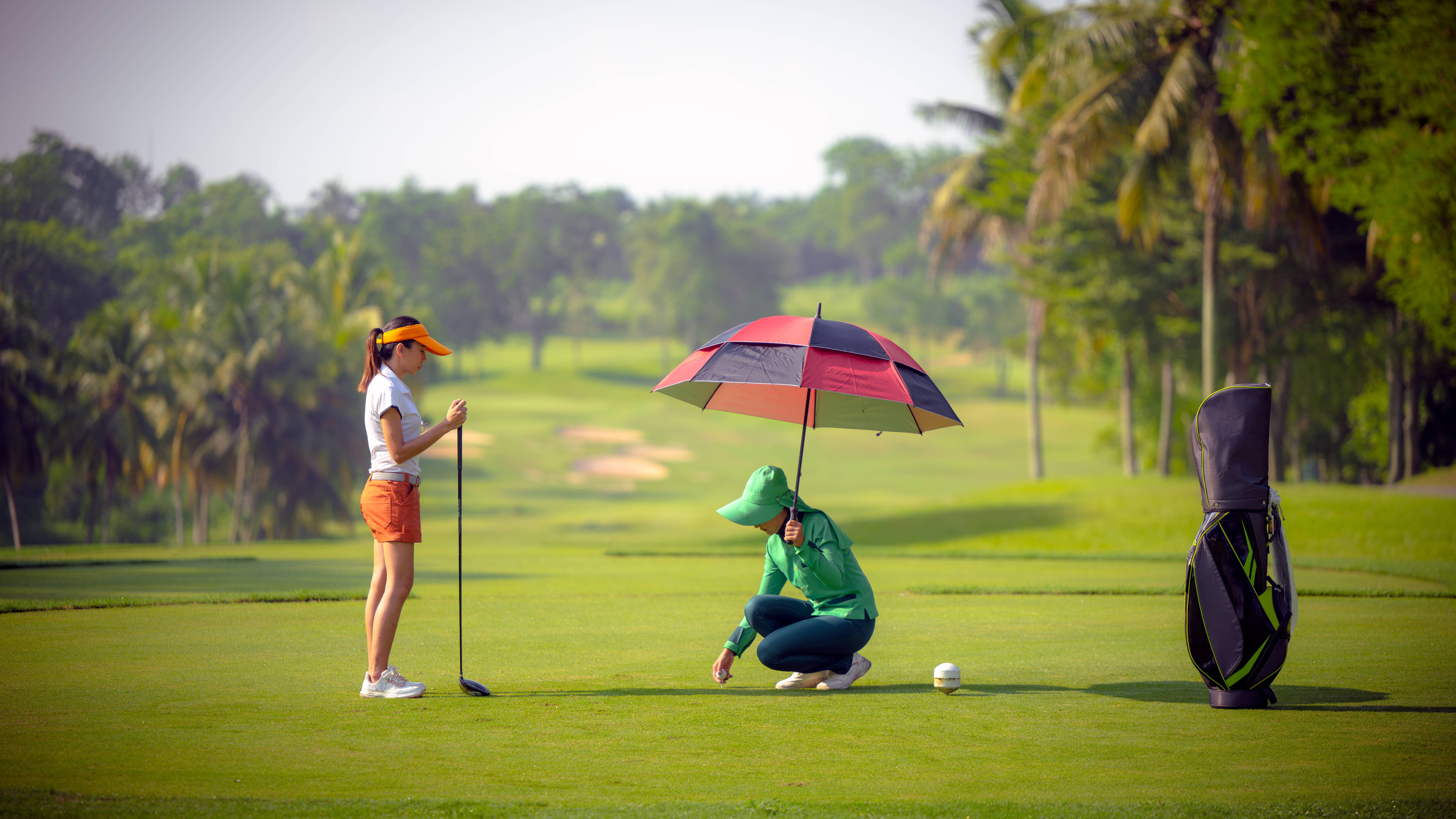 Caddie teeing up a player's ball