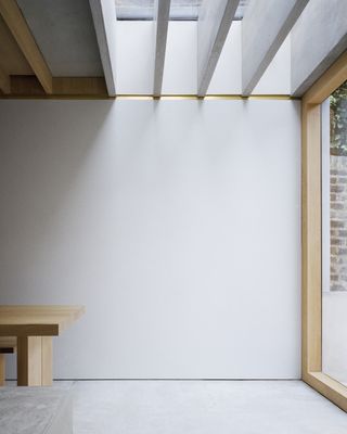 Minimalist room with bench inside Islington House by McLaren Excell
