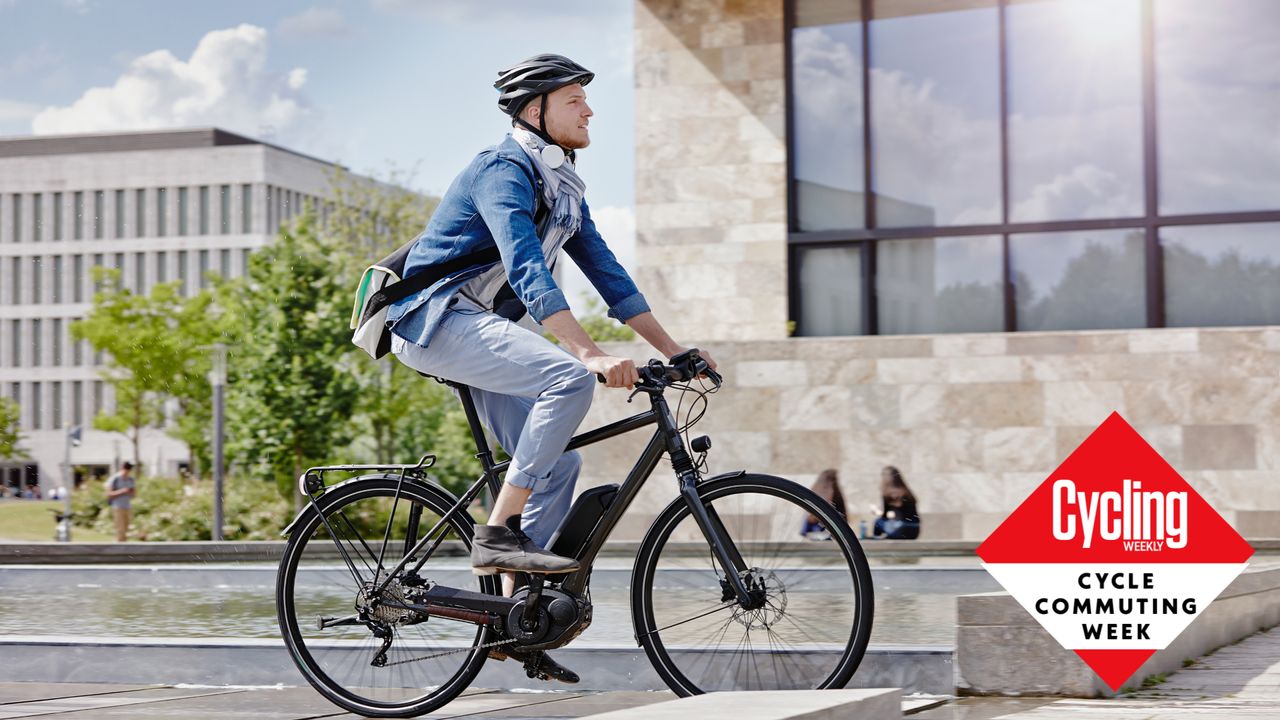 Image shows a man riding a electric bike to cycle commute to work.