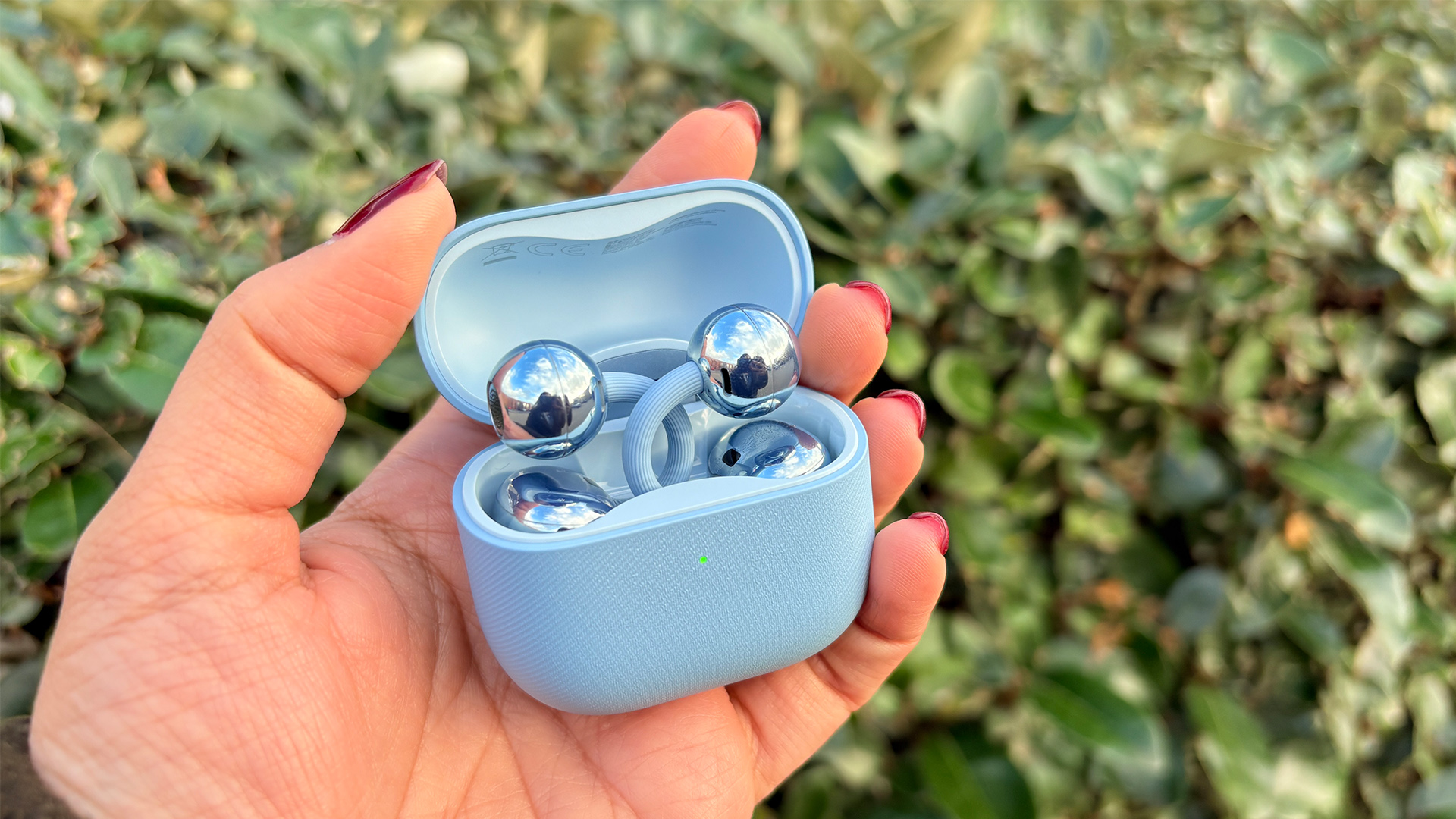 Huawei FreeClip 2 wireless earbuds in open case held in hand