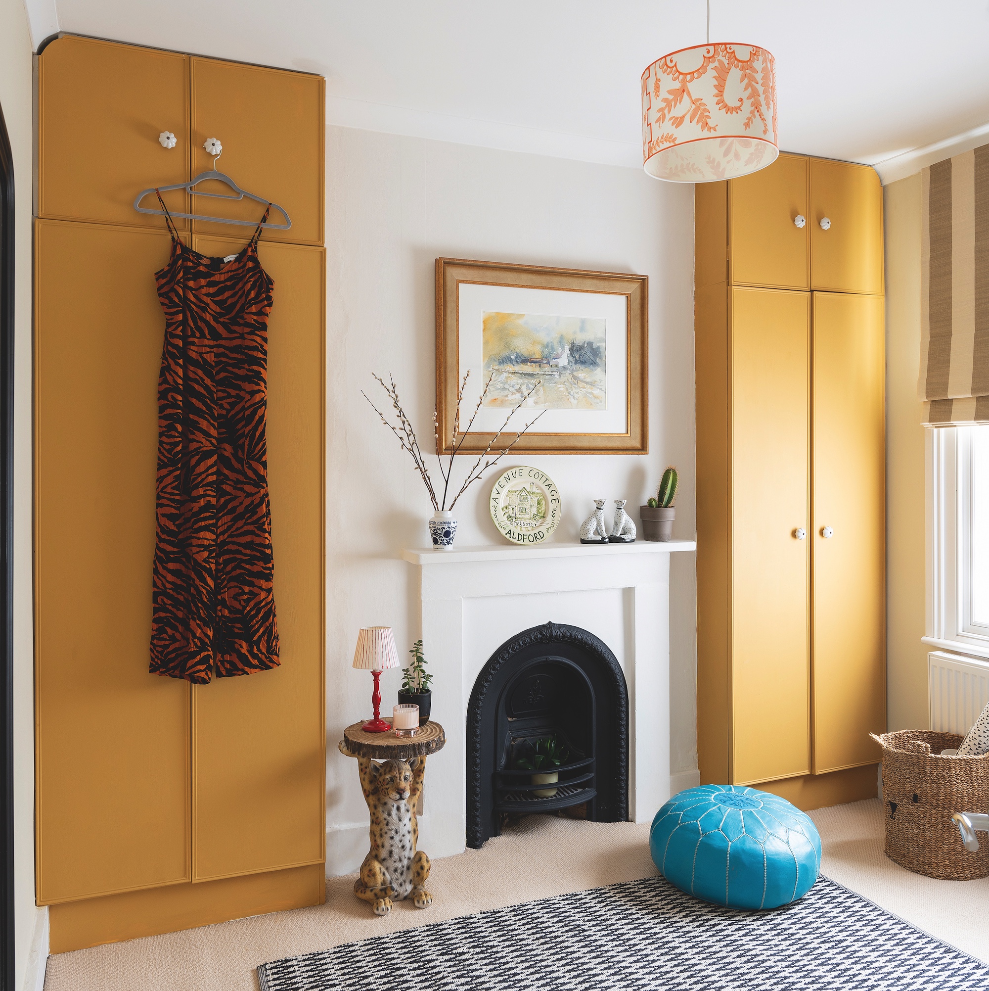 bedroom and dressing room with yellow painted wardrobe cupboards and victorian fireplace painted white