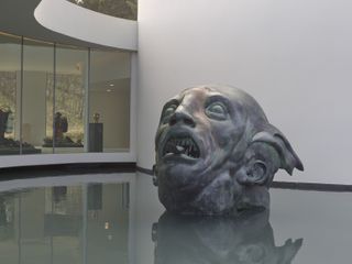 sculpture of man's head in pool