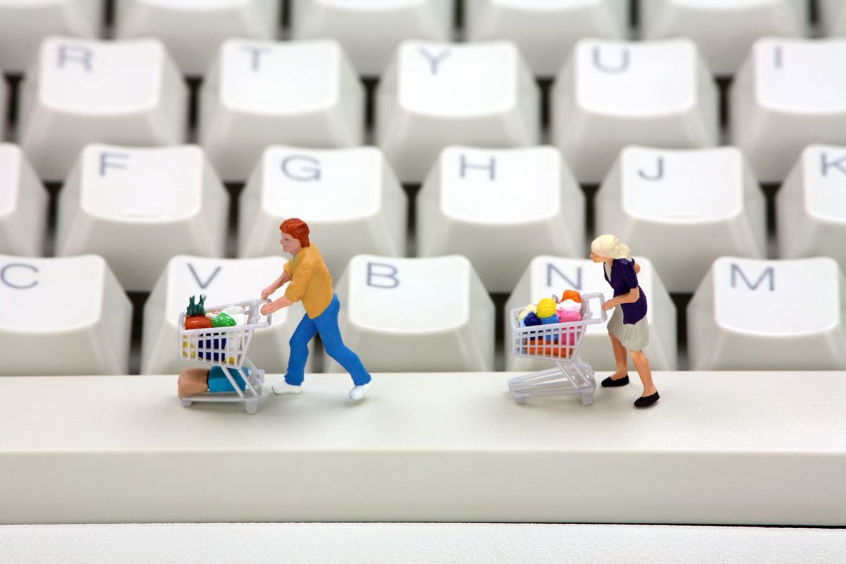 Shoppers with trollies on computer keyboard