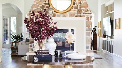 entryway table with foliage and stone chimney breast