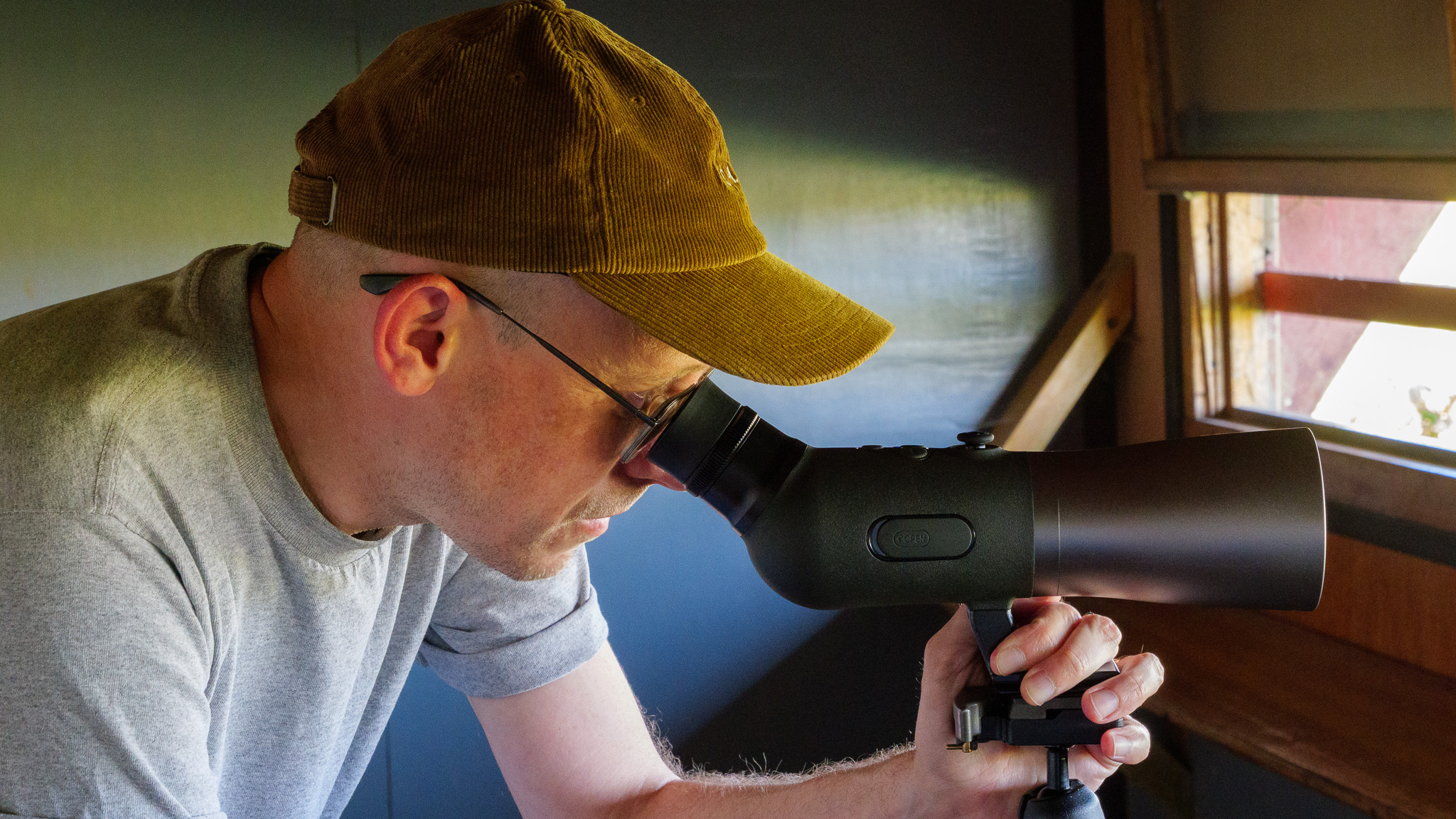 Bird spotting scope on tripod in bird watching hide