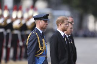Prince William, Prince of Wales and Prince Harry, Duke of Sussex walk behind the coffin during the procession for the Lying-in State of Queen Elizabeth II on September 14, 2022 in London, England.