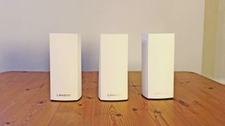 Linksys Atlas Pro 6 routers on a wooden table