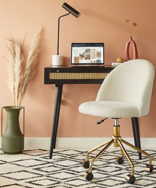 Cream boucle chair with black and rattan desk with pampas grass in khaki vase by Cult Furniture