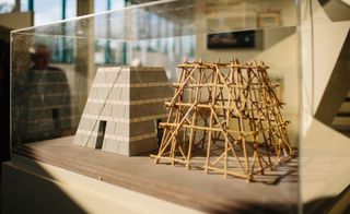 Model pyramid constructed from blocks, beside a stick model of a pyramid