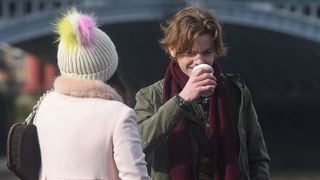 a young thomas brodie sangster drinks a coffee and talks to. a girl in Love Actually