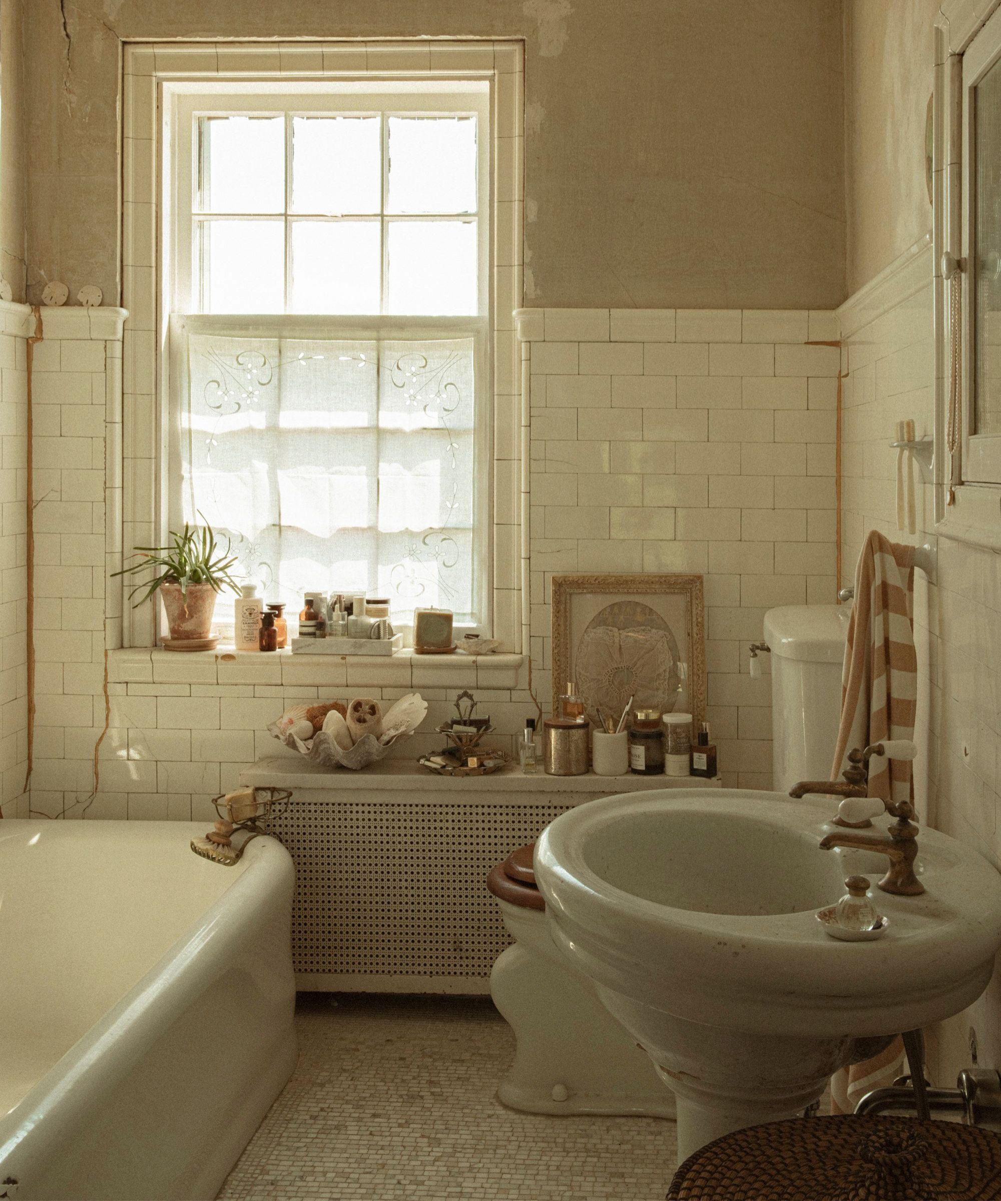 an original bathroom in a historic home with peeling plaster walls and vintage decor