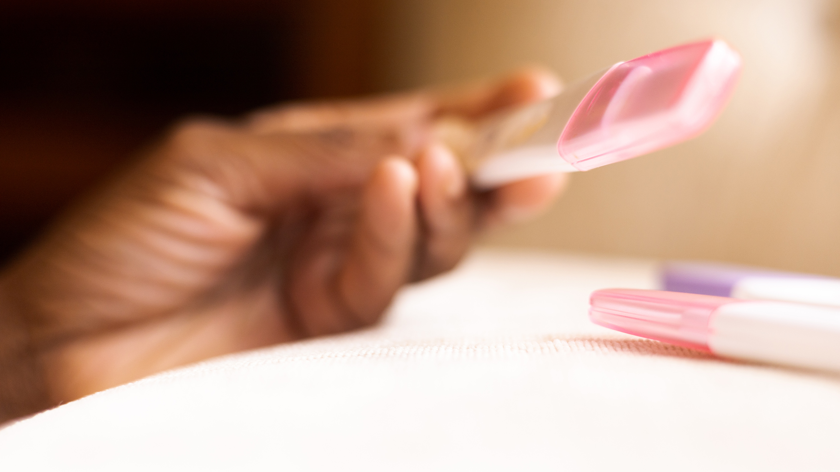 Woman reads the results of an at-home pregnancy test.