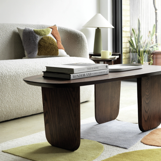 A dark wood coffee table in a cream living room