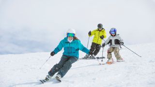 Family skiing together on sunny day