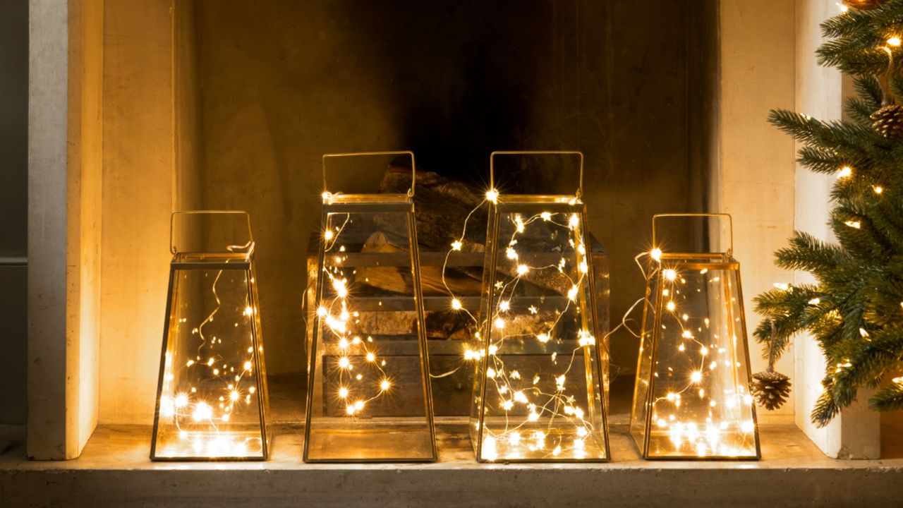 Warm toned fairy lights inside of jars in front of fireplace