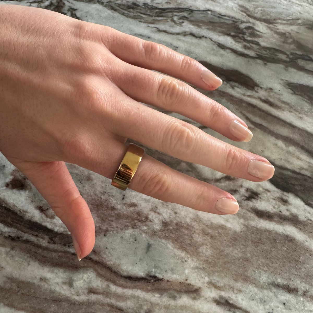 Eleanor's hand, wearing the Oura Ring 4 in gold