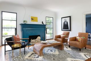 A living room with a turquoise fireplace and contrasting yellow artwork above the mantle