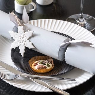 A Christmas table setting with a decorated Christmas cracker