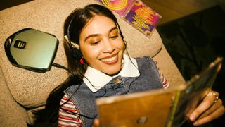 Girl lying on bed with cd player