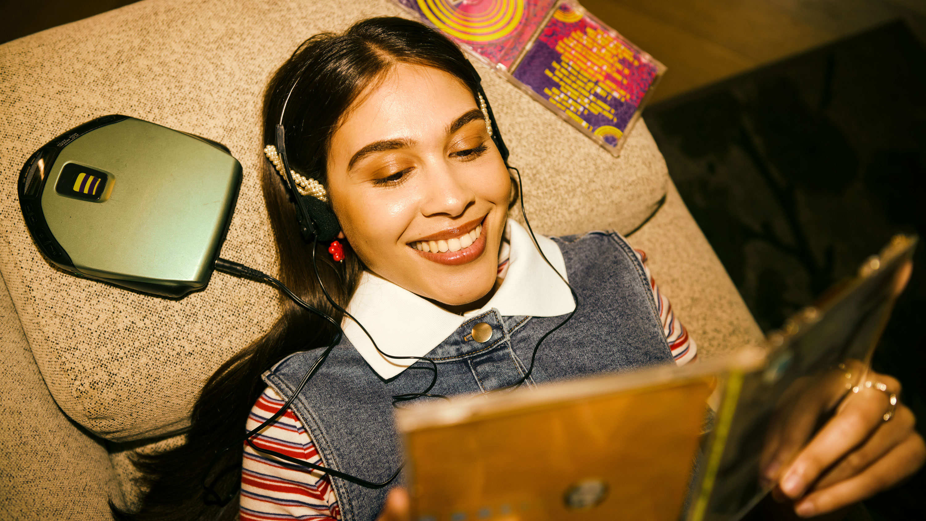 Girl lying on bed with cd player