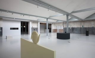 Image shows exhibition of five objects in an industrial space