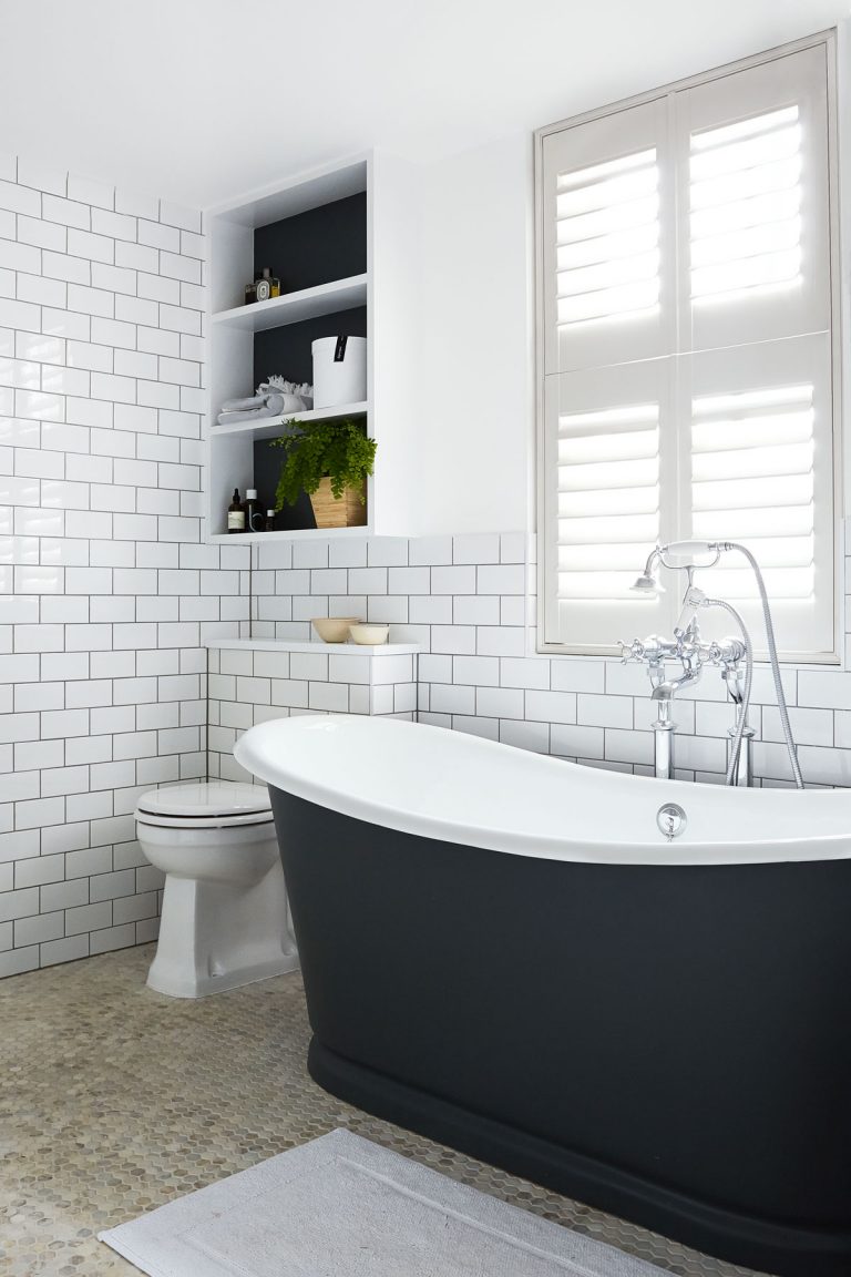 small bathroom with black freestanding bath and white metro tiled walls