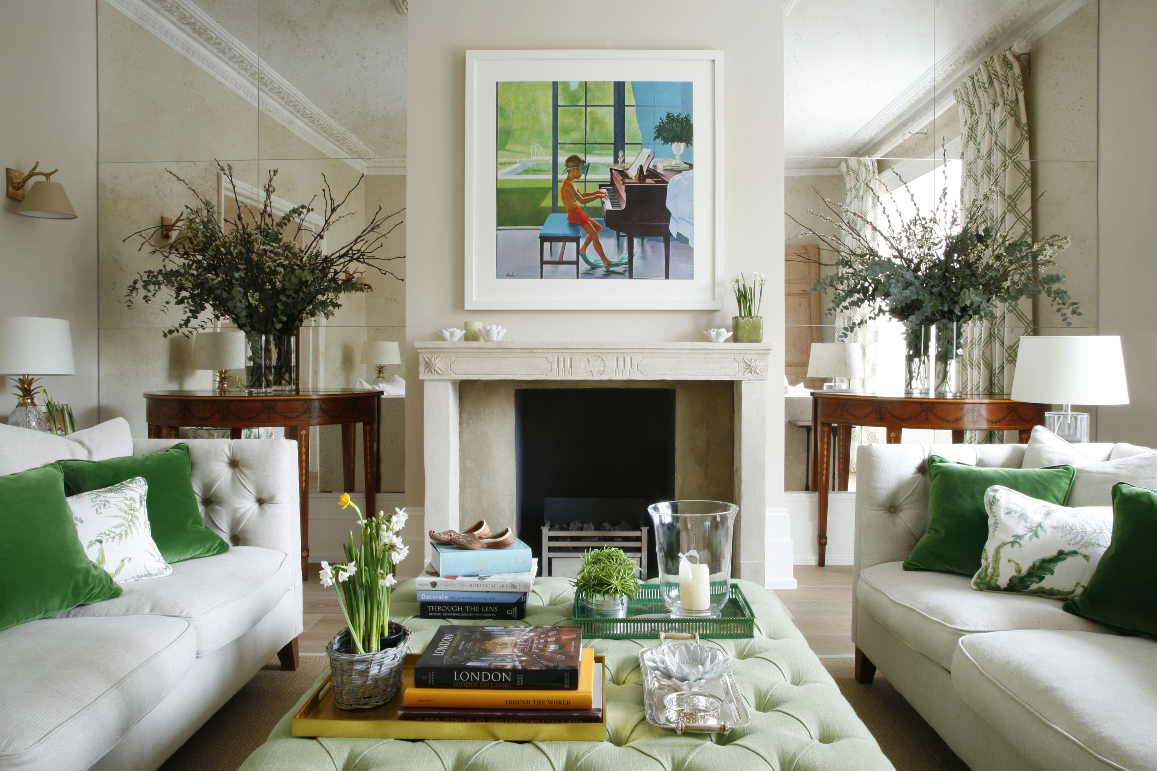 A small living room ideas featuring two white sofas facing each other with green cushion and a green ottoman.